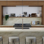 Kitchen with a large island of Mirabel porcelain featuring a light, veined waterfall countertop and matching backsplash.