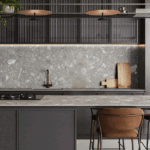 Modern kitchen with dark cabinetry, Caesarstone countertop, pendant lights, and leather chairs. View in room.