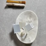 Silica dust protective mask resting on a Caesarstone countertop with color swatches and a brush, representing safe fabrication practices and design precision.